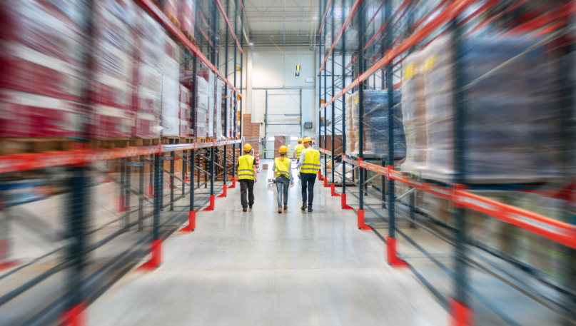 three people walking through a warehouse