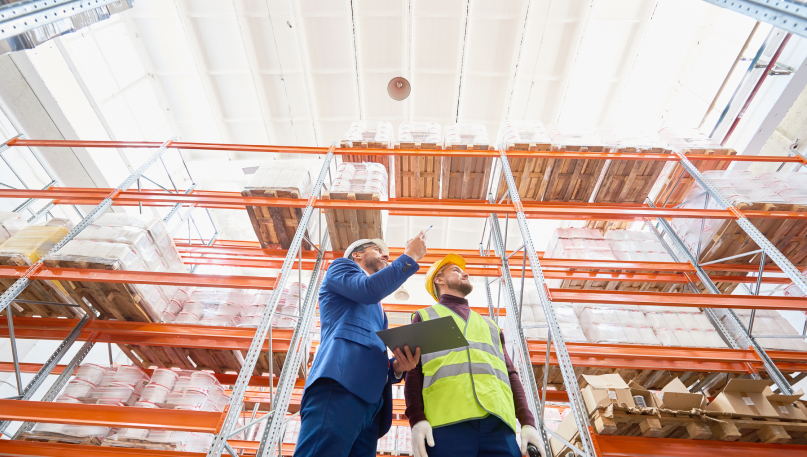 two men taking inventory inside of warehouse